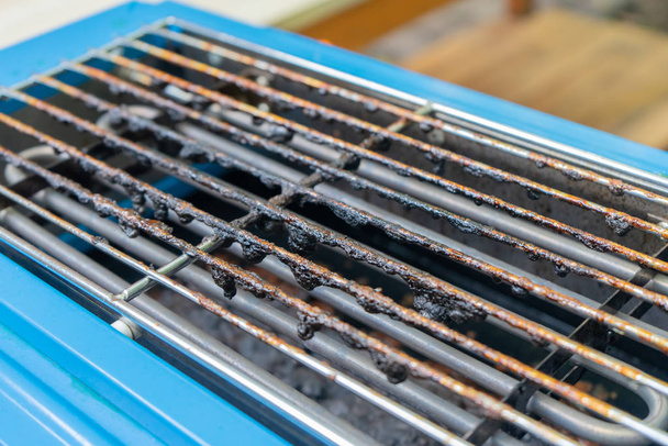Sucia marca negra quemada en la parrilla encima de la estufa eléctrica azul fro
 - Foto, Imagen
