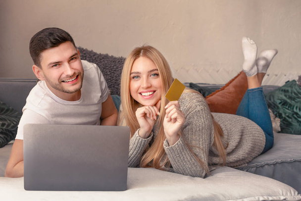 Heureux couple souriant en utilisant un ordinateur portable dans la chambre
 - Photo, image