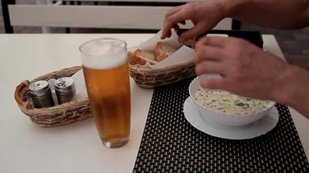 male hands take bread and start eating cold soup - Footage, Video
