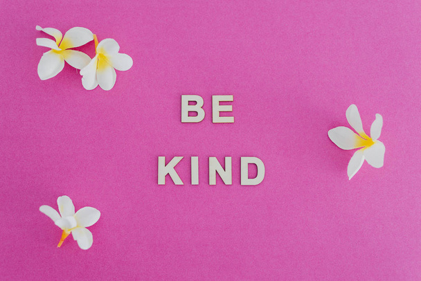 Be Kind message on pink background surrounded by flowers, concep - Foto, Bild