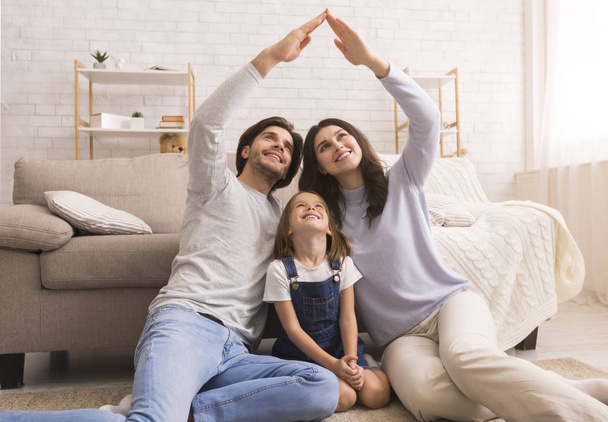 Caring parents making symbolic roof of hands above little daughters head - Photo, Image