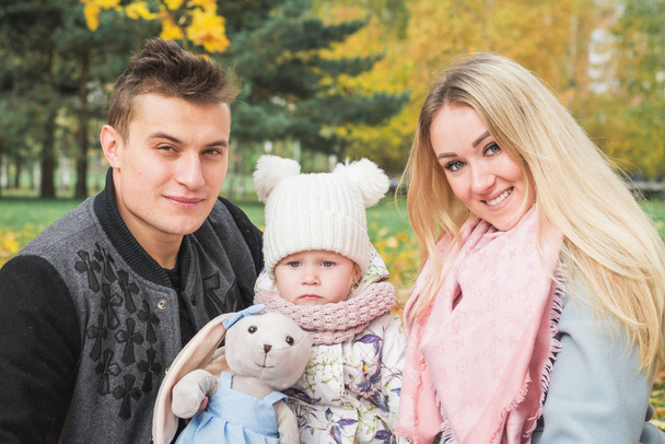 Young happy family in the autumn park - Foto, Imagen