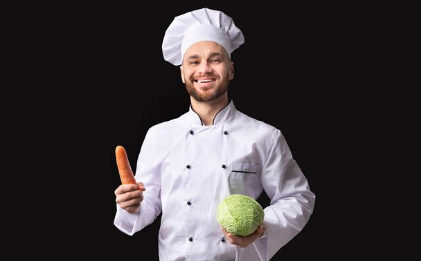 Chef feliz hombre posando sosteniendo zanahoria y col, Studio Shot
 - Foto, imagen