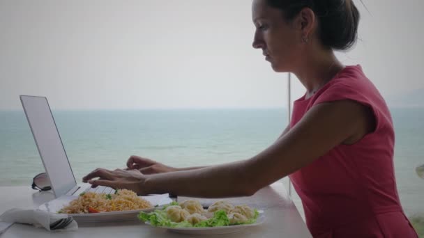 Kobieta pracująca z widokiem na ocean - Materiał filmowy, wideo
