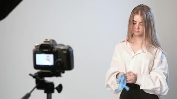 Beleza blogueiro apresenta cosméticos, de pé na frente da câmera de gravação de vídeo
 - Filmagem, Vídeo