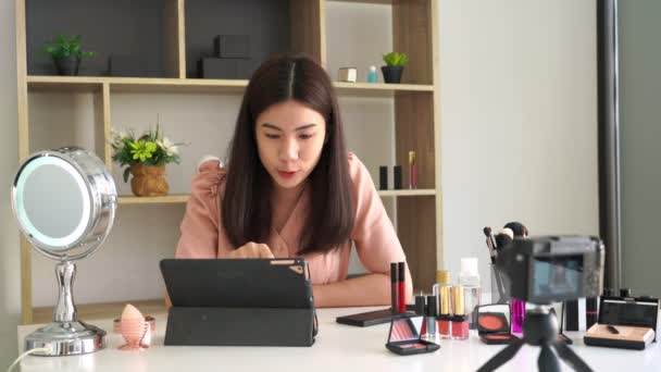 4k Video des berühmten Bloggers. Fröhliche Vloggerin zeigt Kosmetikprodukte, während sie Videos für das alltägliche Make-up-Tutorial aufnimmt. bei der Arbeit. - Filmmaterial, Video