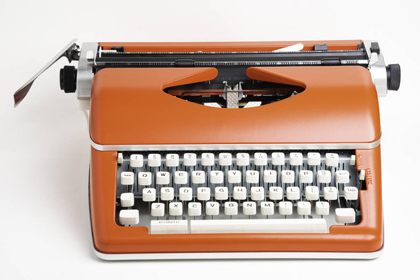 Máquina de escribir manual portátil en rojo naranja
 - Foto, Imagen