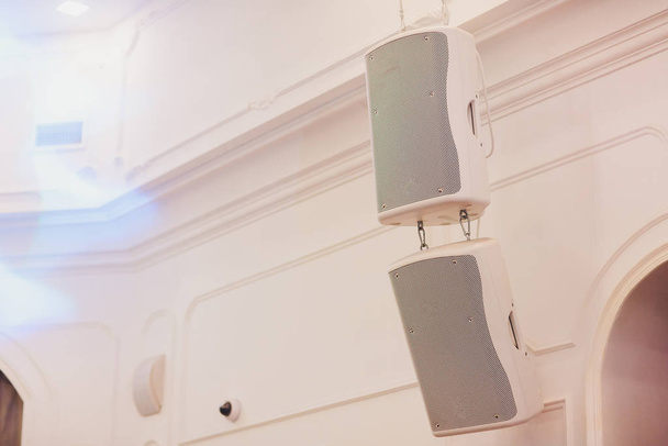 Musical speaker column on a white wall ceiling. - Photo, Image