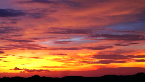 zachód słońca czerwony pomarańczowy żółty zachmurzone niebo na górze sylwetki - Materiał filmowy, wideo
