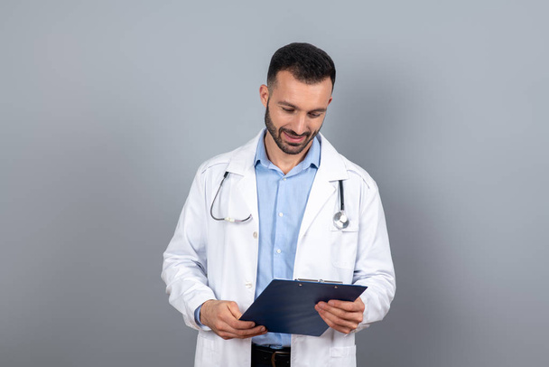Doctor in white robe reading a medical case - Zdjęcie, obraz