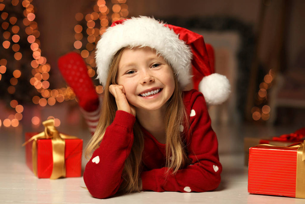 Cute little child with Christmas gifts at home - Foto, Bild