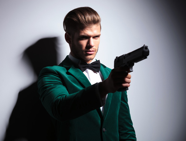 James Bond wannabe young assasin pointing his big pistol - 写真・画像