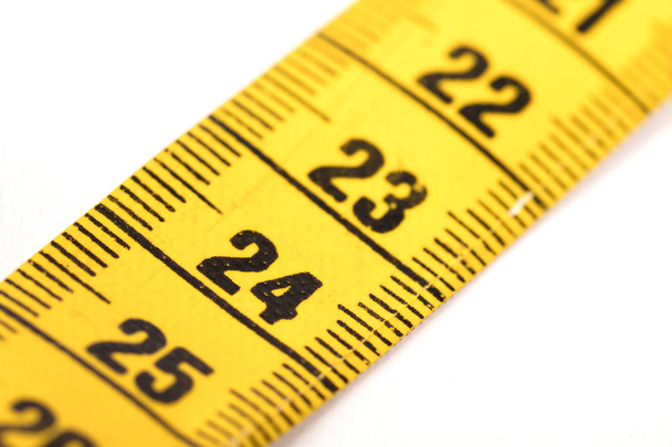 Close-up de uma fita métrica amarela isolada em branco - 24
 - Foto, Imagem