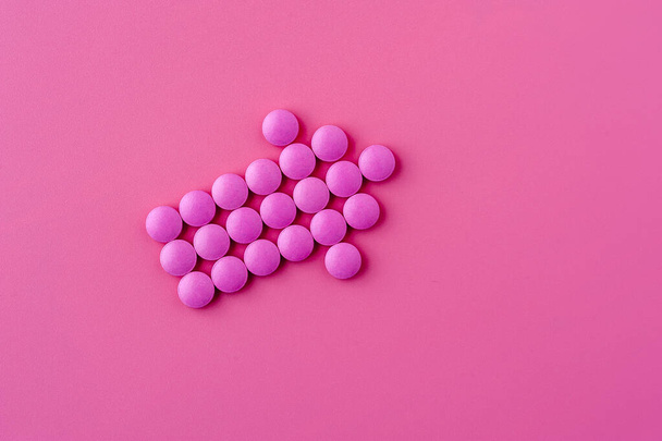 Close-up of pink pills lie on a pink surface - Foto, Imagem