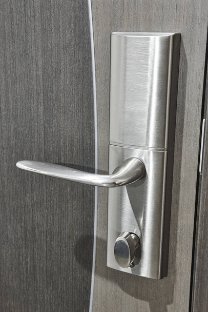 Pomo de puerta de acero con cerradura en una puerta de madera gris
  - Foto, Imagen