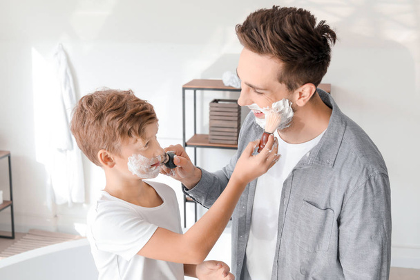 Père avec fils appliquant de la mousse à raser sur leurs visages dans la salle de bain
 - Photo, image