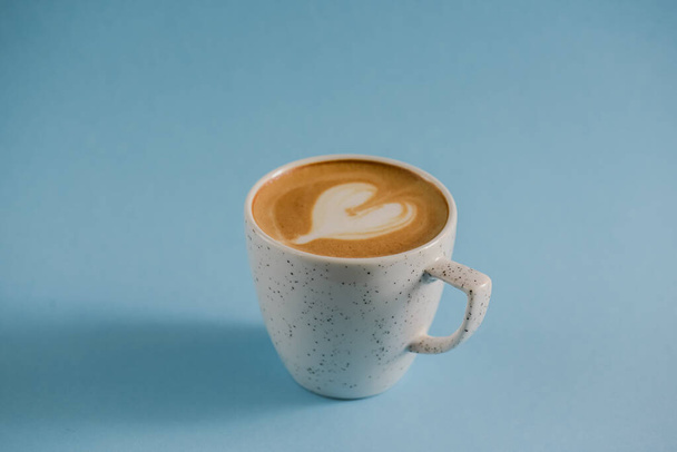 Latte art on top hot coffee cup over pastel blue background. Heart latte art. Copy space banner. - Photo, Image