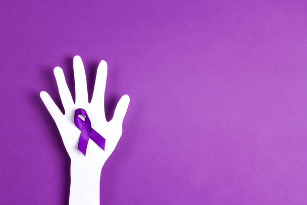 Purple awareness ribbon and paper hand silhouette on a purple ba - Foto, afbeelding