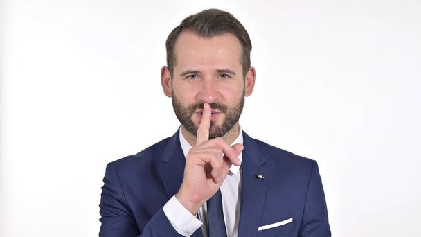 Retrato del joven empresario poniendo dedo en los labios, fondo blanco
 - Foto, imagen