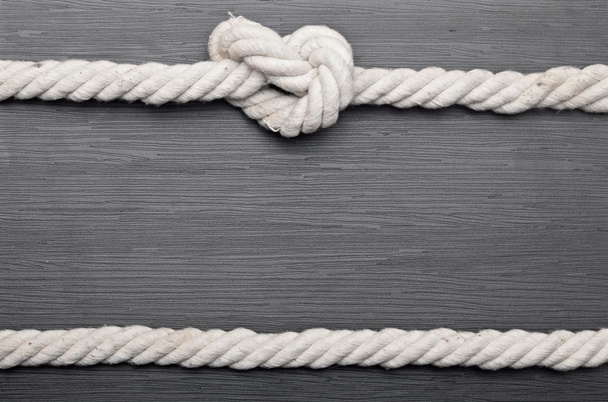 marco hecho de cuerda sobre un fondo de madera
 - Foto, imagen