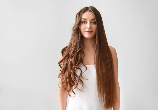 Kaunis nainen kihara ja sileä hiukset valkoisella taustalla
 - Valokuva, kuva