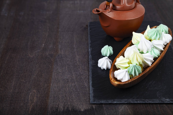 Meringue in a wooden bowl and kettle  - Foto, Imagen