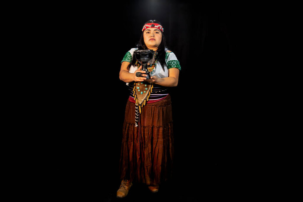 jonge vrouw Teotihuacana, Xicalanca - Toltec in zwarte achtergrond, met traditionele jurk dans met een trappings met veren en trommel - Foto, afbeelding
