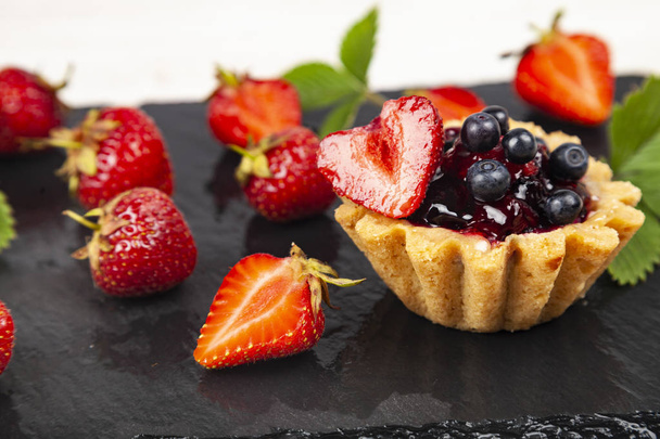 Small berry cake and strawberries  - Fotó, kép