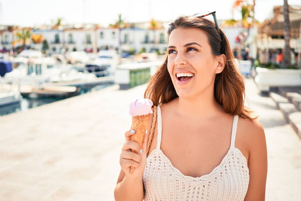 Joven hermosa mujer comiendo helado cono en un día soleado de verano en vacaciones
 - Foto, imagen