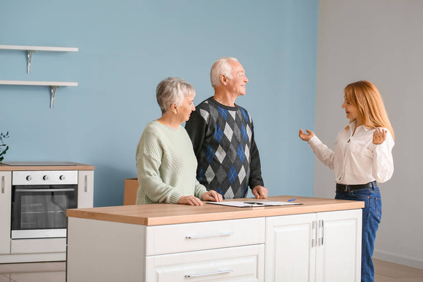 Женщина-агент по недвижимости работает с пожилой парой в помещении
 - Фото, изображение
