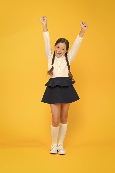 Back to school. Student little kid adores school. Emotional schoolgirl. Celebrate knowledge day. September time to study. Girl adorable pupil on yellow background. School uniform and fashion - Фото, зображення