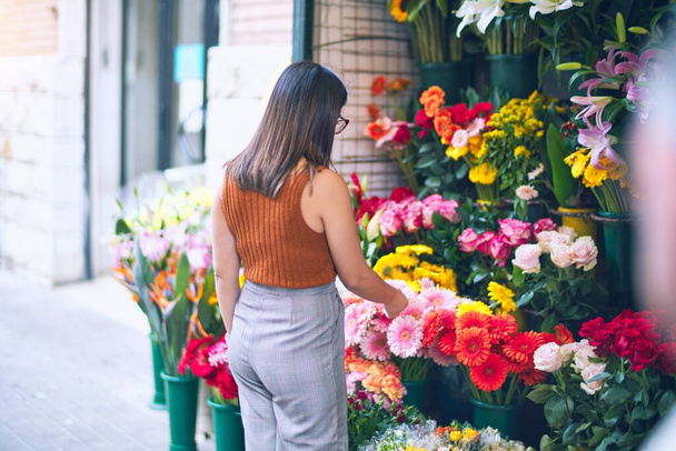 Young beautiful woman smiling happy and confident. Standing with smile on face at florist - Foto, Imagem