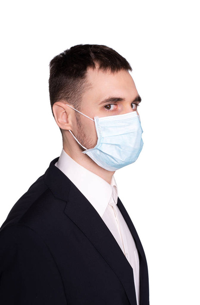 Un jeune homme dans un masque médical avec un visage effrayé
. - Photo, image