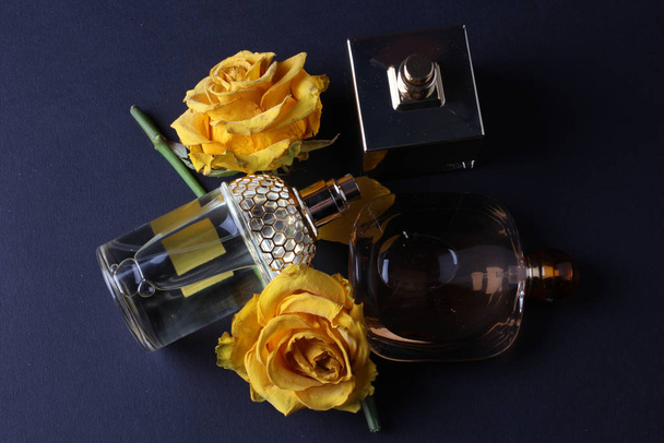 conjunto de perfumes de aroma con flores de rosa sobre fondo oscuro
 - Foto, Imagen