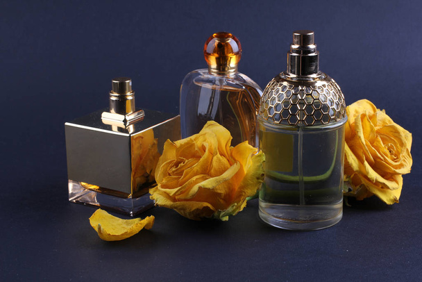 Parfüms mit Rosenblüten auf dunklem Hintergrund - Foto, Bild