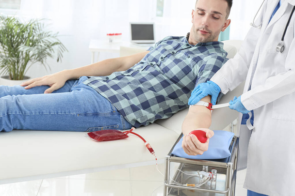 Medico femminile che prepara il donatore maschio per la trasfusione di sangue in ospedale
 - Foto, immagini