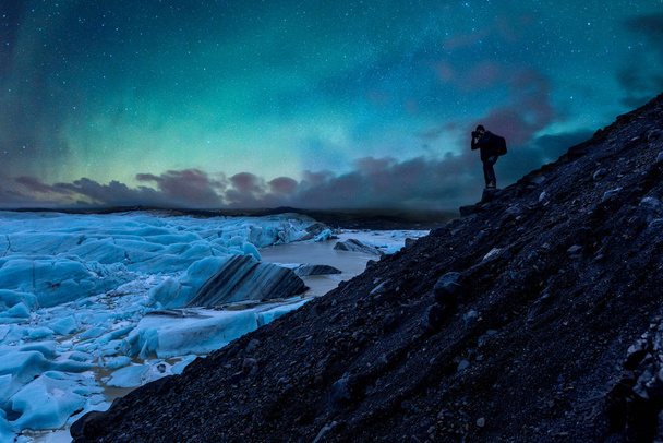 Photographer taking photos of glacier and northern lights in Ice - Fotó, kép