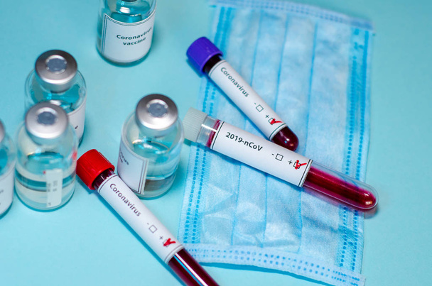 Test tube with positive Coronavirus test blood sample and vaccin - 写真・画像
