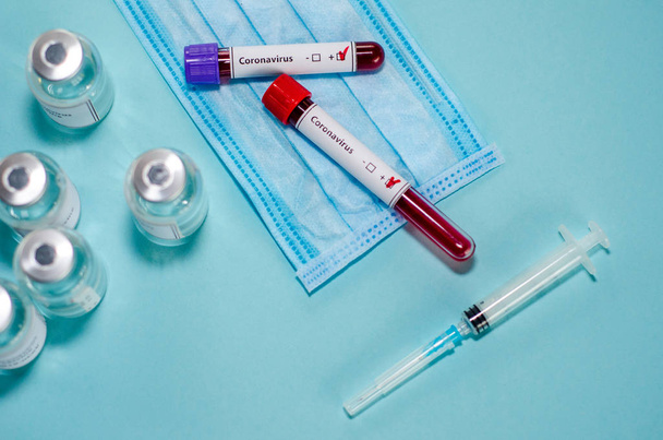 Test tube with positive Coronavirus test blood sample and vaccin - Fotoğraf, Görsel