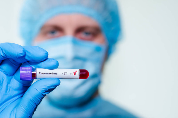 Medical laboratory assistant holding test tube with positive Cor - Fotoğraf, Görsel
