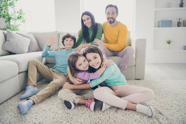 Portrait of nice attractive lovely adorable perfect glad big full cheerful cheery family pre-teen kids mom dad spending time embracing at cozy comfortable light white interior style house living-room - Fotografie, Obrázek