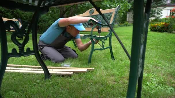 El carpintero desmonta el banco retro. Escalones de renovación de muebles exteriores
 - Imágenes, Vídeo