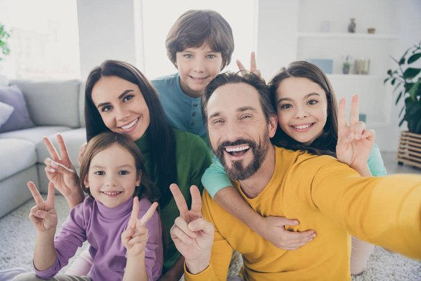 Self-portrait of nice attractive big full cheerful cheery glad family pre-teen kids mom dad having fun showing v-sign at cozy comfortable light white interior style house apartment - Fotografie, Obrázek