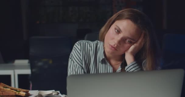 Close up of woman almost falling asleep while working long hours on laptop.Tired sleepy female office worker working late at night .Concept of overwork and workaholism. - Materiaali, video