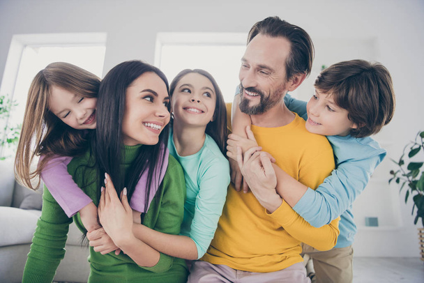 Close-up portrait of nice attractive lovely affectionate adorable friendly careful cheerful cheery family three pre-teen kids mom dad embracing having fun at light white interior style house - Foto, Imagem