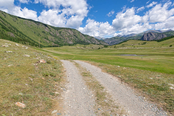 Beautiful dirt road in the mountains of Altai, against the backd - 写真・画像