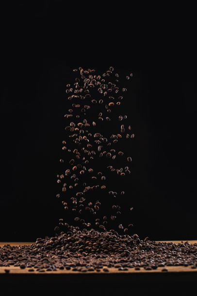 fresh roasted coffee beans in air isolated on black - Fotó, kép