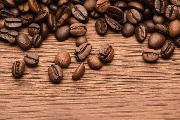top view of fresh roasted coffee beans on wooden table - Foto, Imagem