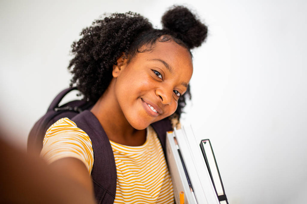 Közelkép portré fekete lány diák csinál szelfi ellen elszigetelt fehér háttér - Fotó, kép