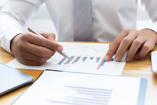 Businessmen use graphs to summarize results and calculate income-expenses to find financial balance points and use them to improve and advance business, finance and economic concepts. - Photo, Image